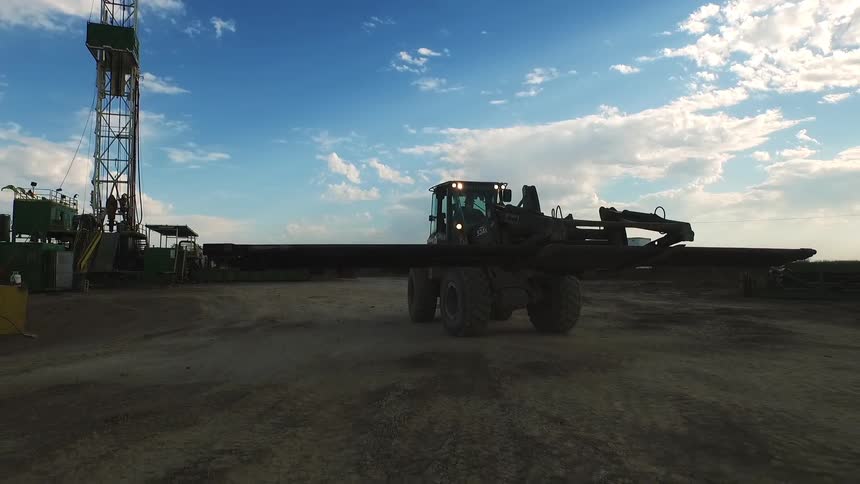 A construction vehicle moves a large metal beam