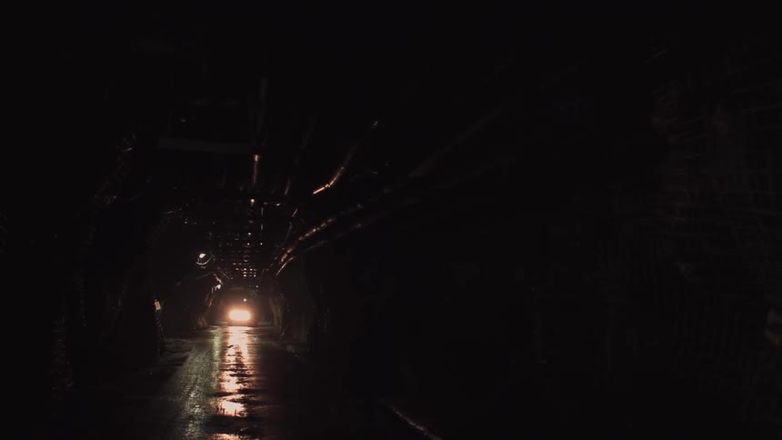 Down the dark tunnel a vehicle is driving