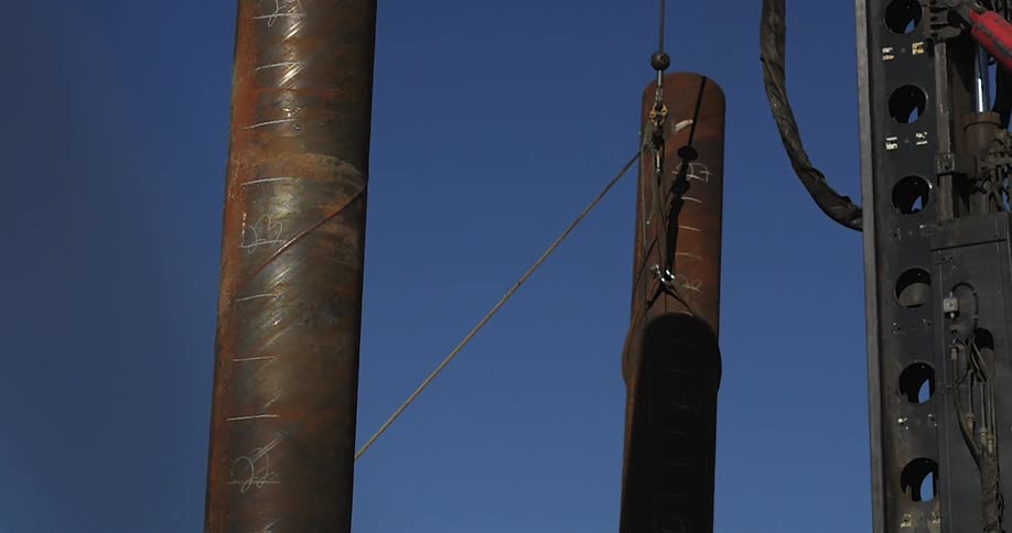 Large metal pipe being lowered down