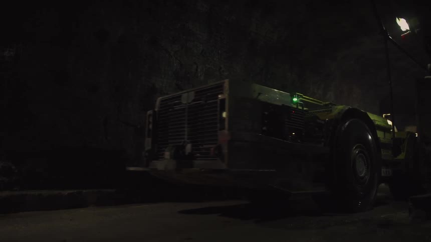 Tractor rolling down a road in the dark