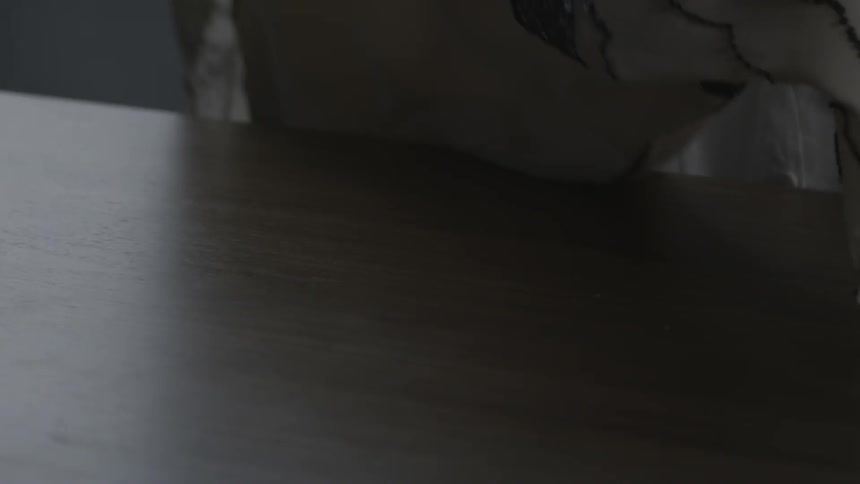 A person lays a dress on the table