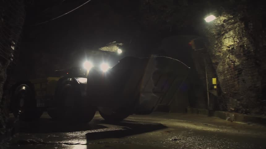 A bulldozer drives through a tunnel