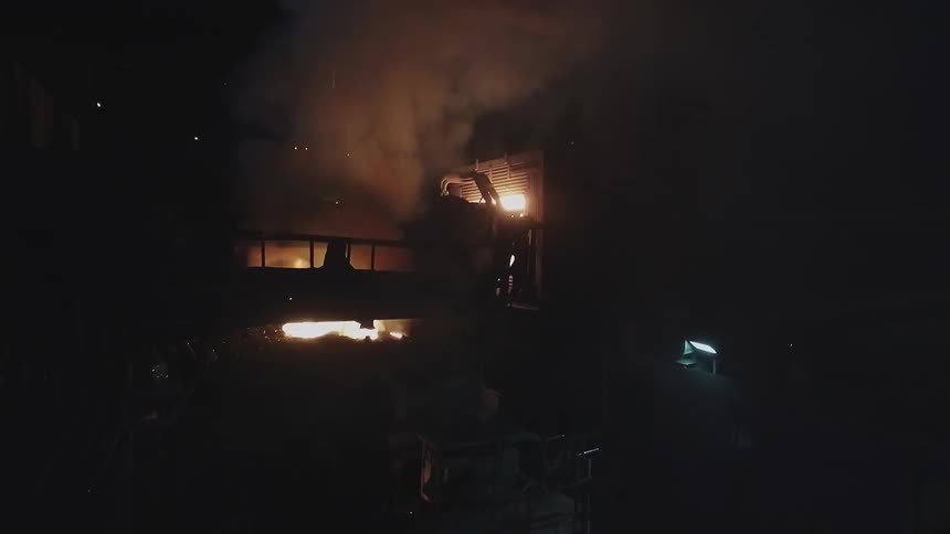 A fire burns in a factory setting