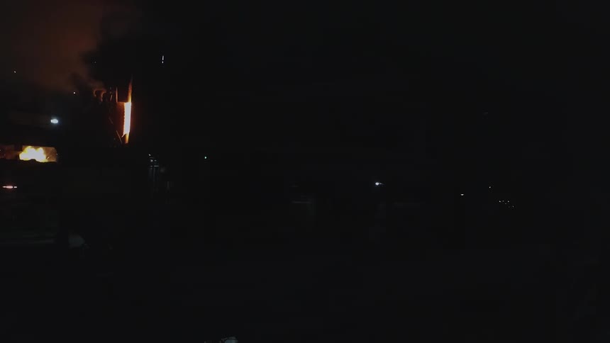 A machine is giving off flames and steam in the dark