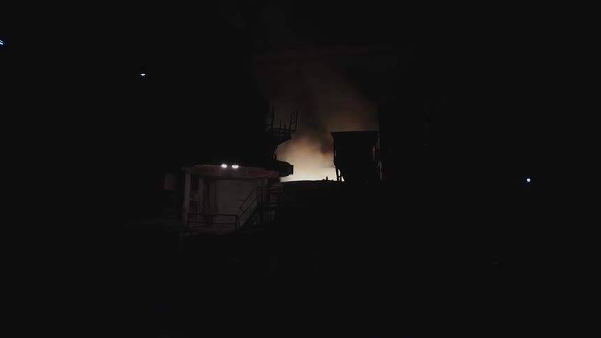 Smoke billowing out of a large machine at night