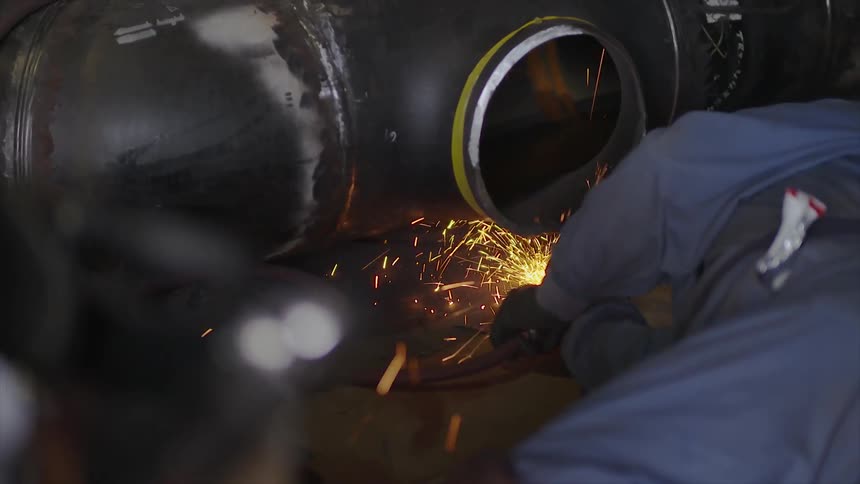 A worker is welding on the ground