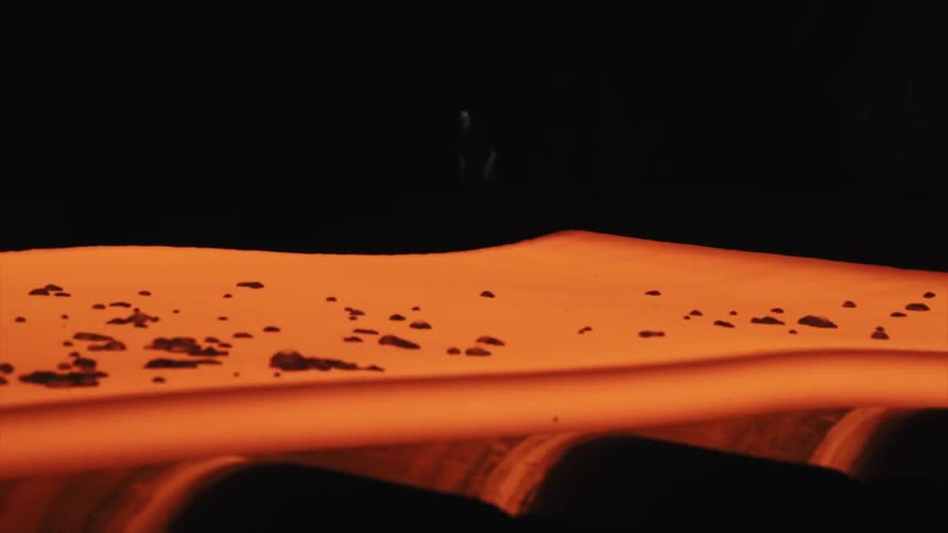 Molten looking sheet rolling on a conveyor belt