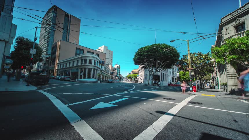 Time lapse of people and cars going by in a city intersection