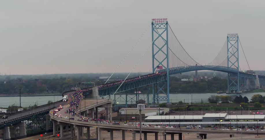 Cars are driving around a highway leading to a bridge