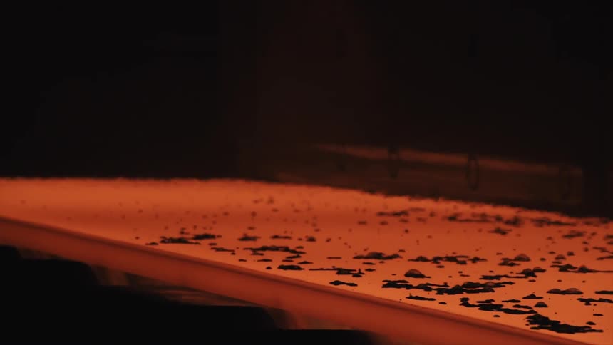 Molten looking sheet rolling on a conveyor belt