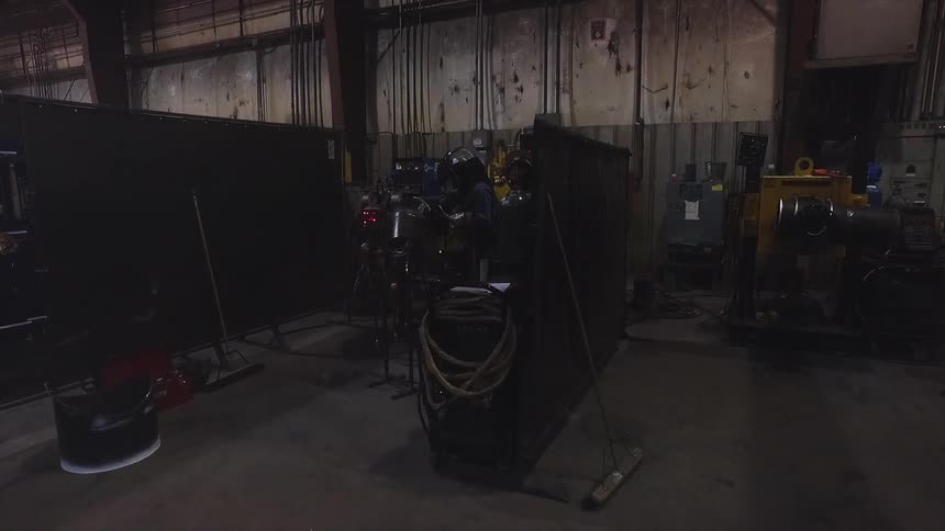 A welder works in a factory setting