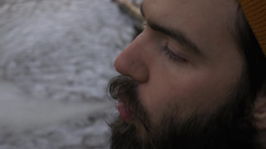 A man lights his pipe and takes a smoke
