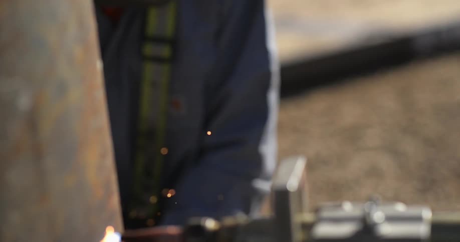 A man is wearing a welding mask as he works