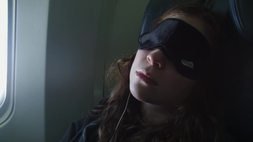 A woman is sleeping with a blindfold