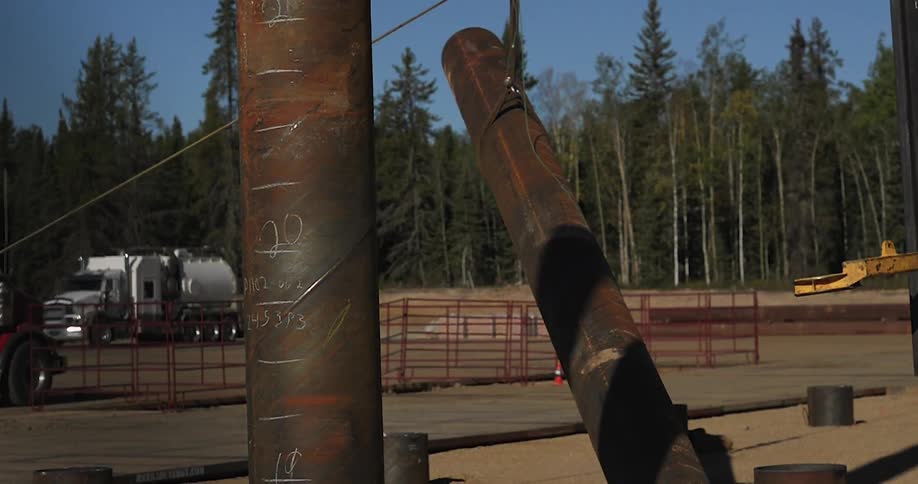 A long metal tube is lowered with a crane