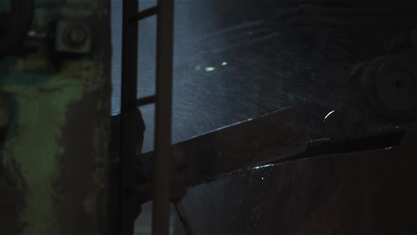 Steam and water spew from a piece of equipment in a factory