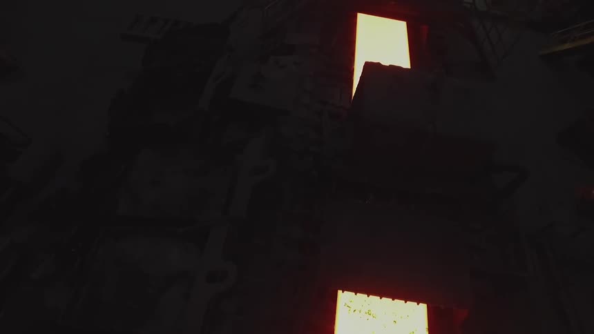 A conveyor belt is moving in a dark area