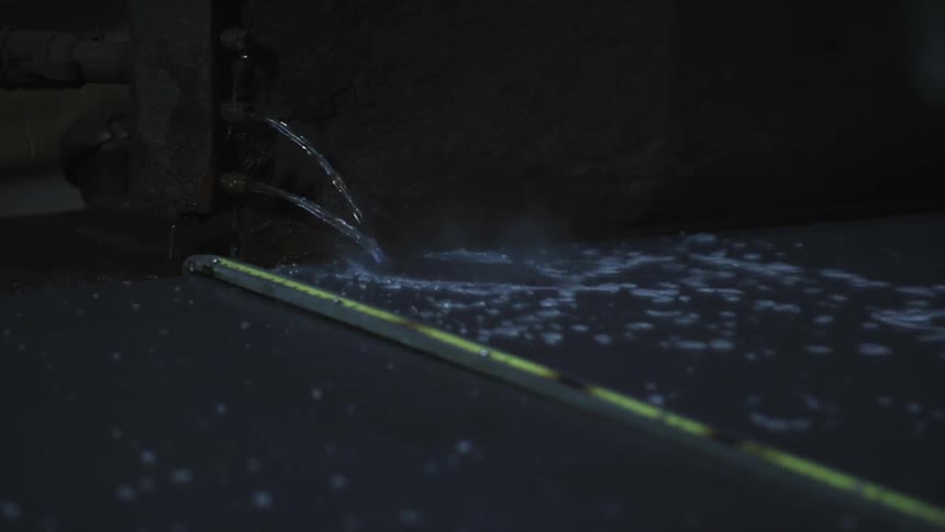 Water streaming into a pool with a tape measure across it