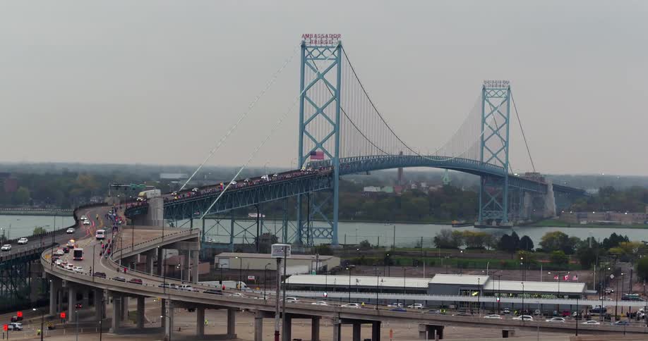 Cars driving on a busy highway to go over a blue bridge