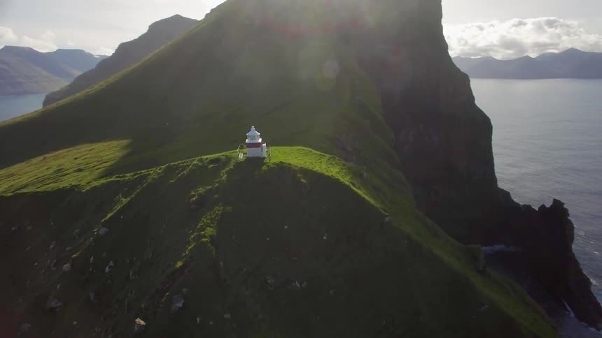 A building sits on a mountain peak on the coast