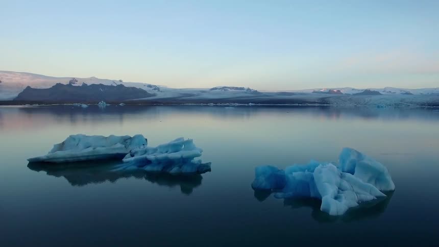 Glaciers on a lake surrounded by snowy mountains
