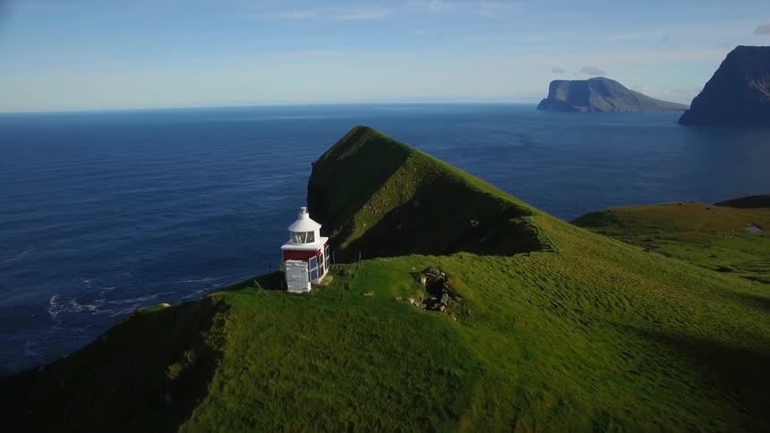 The mountains are green with waves crashing below