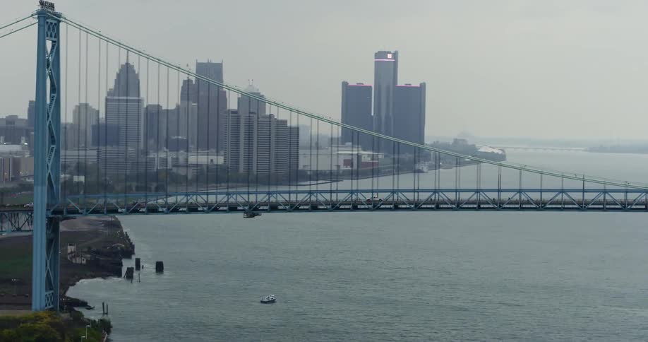 Large bridge going over a river with a city in the background