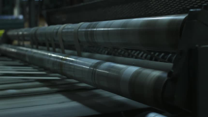 An industrial machine spins rapidly as material moves beneath it