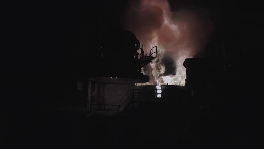 Smoke billowing out of a large machine at night
