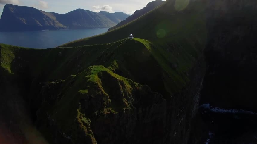 Lighthouse on top of a cliff near water