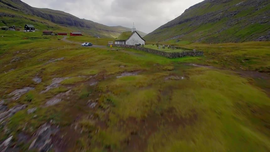 The mountain is green with some houses at the top