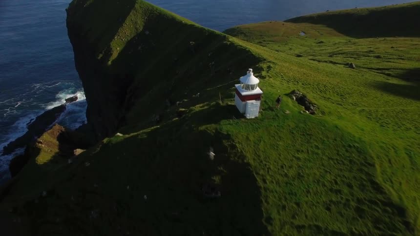 Lighthouse on top of a cliff near water