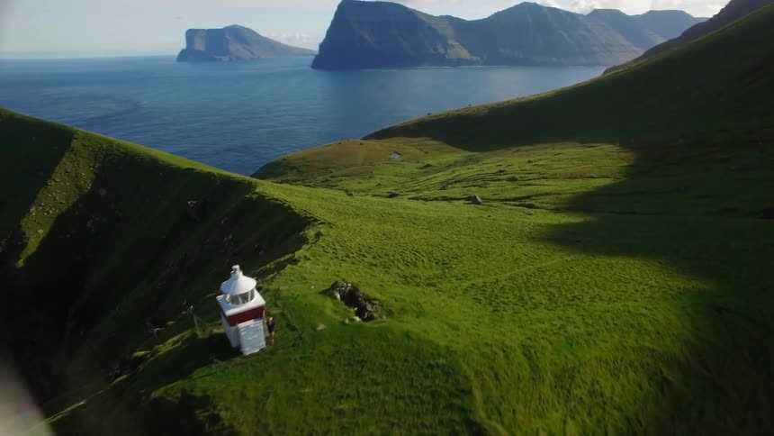 Lighthouse on top of a cliff near water