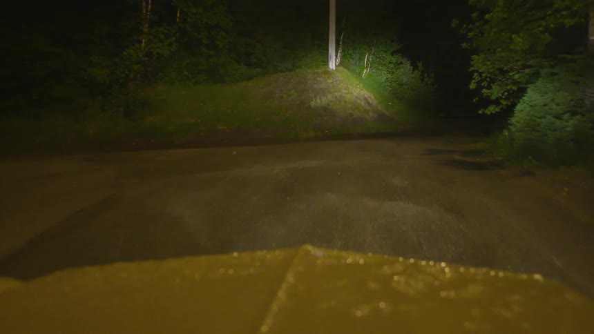 Truck drives out a wet country road at night