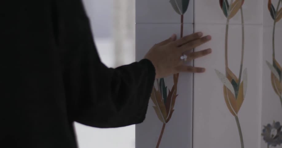 A person walks past a pillar touching it