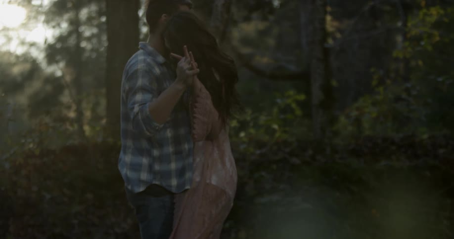 Man and woman dance outside in the woods