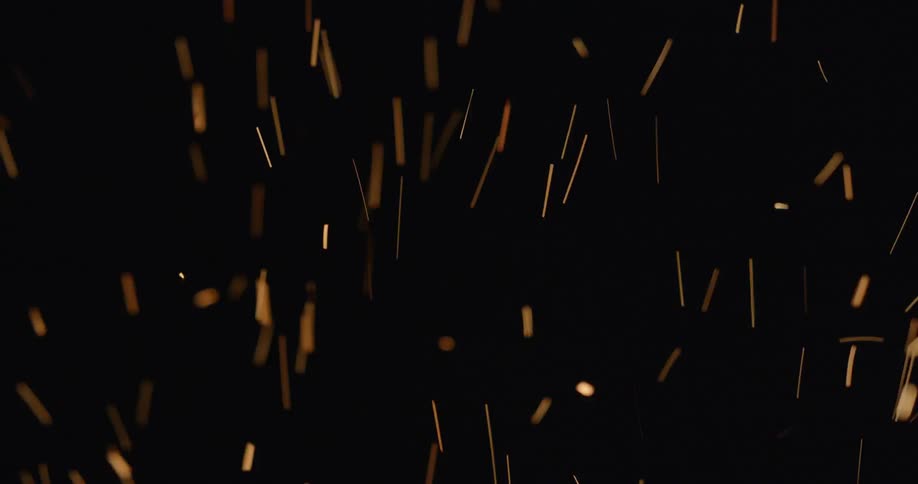 Sparks fly up against a dark background