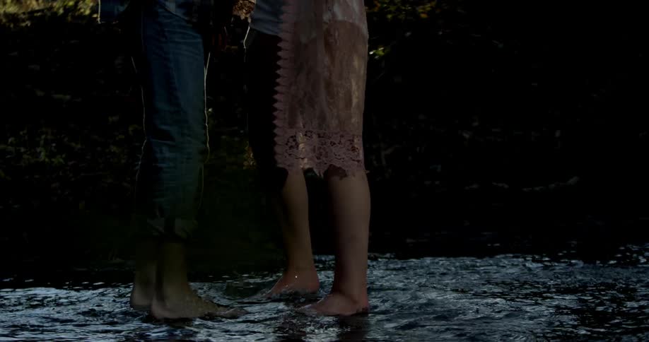 Man and woman walk in a shallow stream