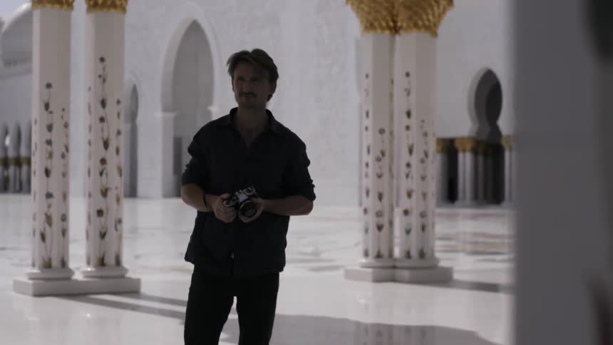 A man is taking photographs near a temple