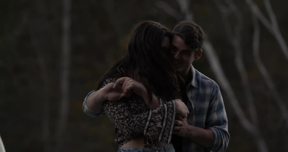 A man and woman laugh and dance outside