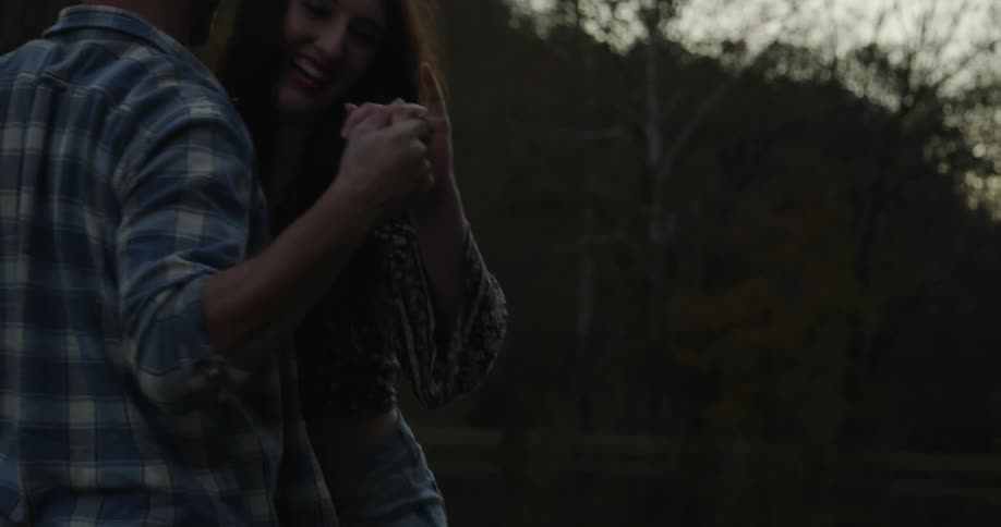 Man and woman dance outside at night