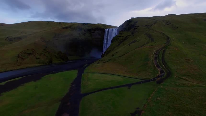 The hills are green with a waterfall at the top
