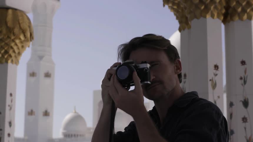 A man lifts his camera to take a picture