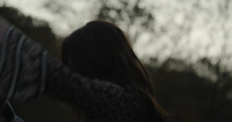 A man and woman smile while dancing outside