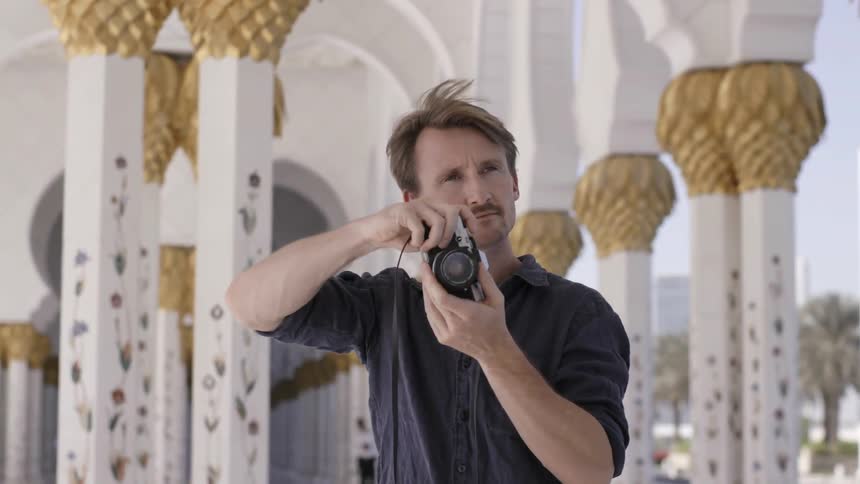 Man with a camera stands in the middle of a temple