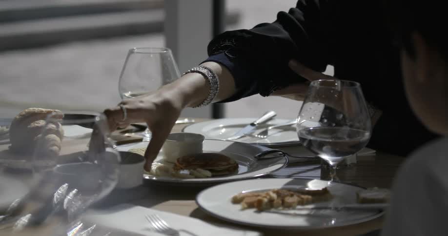 People eat at a table outside on a sunny day