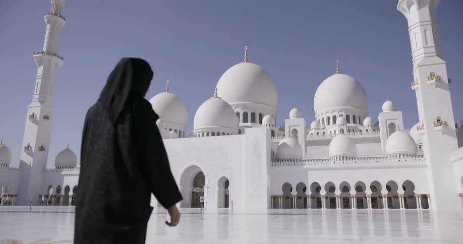 A person walks towards a white temple