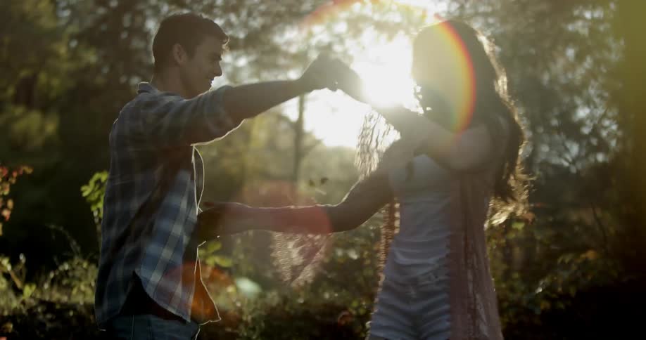 Woman and man dance in the woods on a sunny day