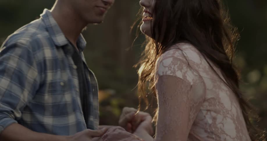A man and woman dance outside on a sunny day
