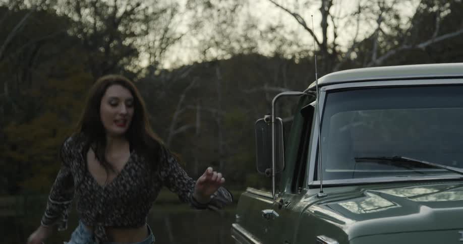 A woman gets out of a truck and runs around
